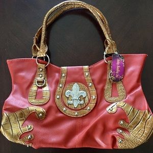 Leather bag with rhinestone fleur-de-lis design.